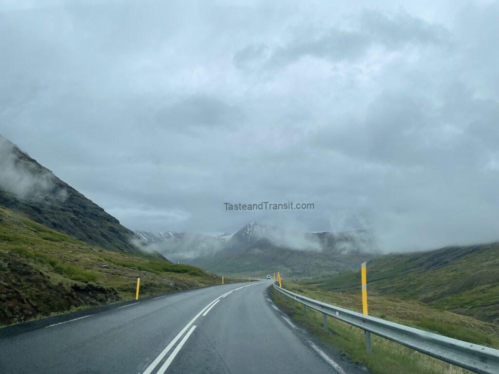 Winding asphalt road through scenic foggy mountains in Iceland
