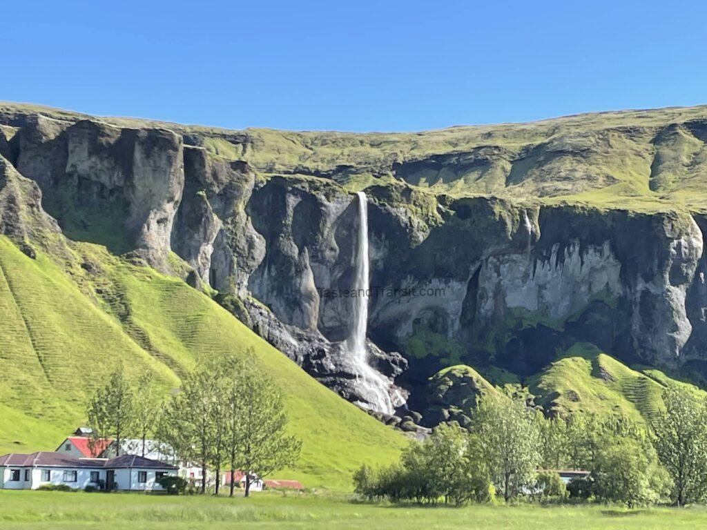 Waterfall cascading down green cliffs in Iceland