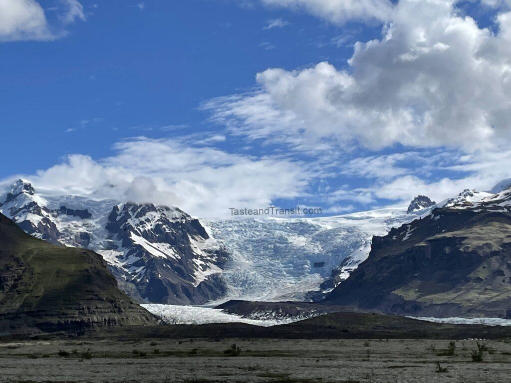 Snowy mountain peak with glaciers under a blue cloudy sky in Iceland