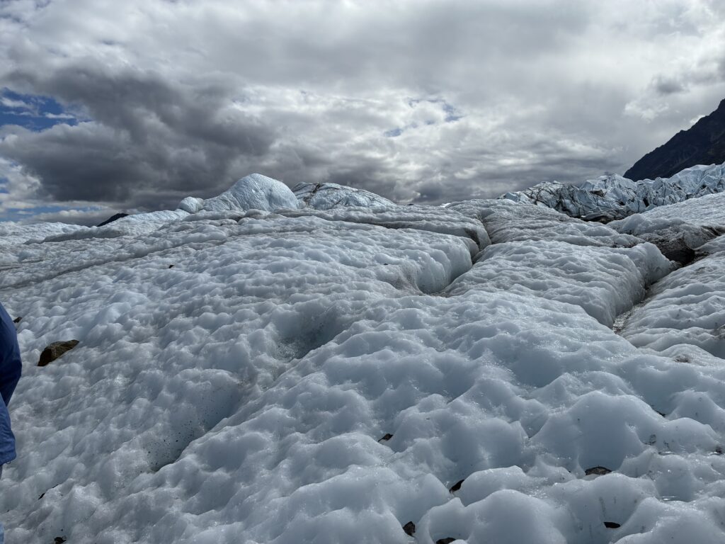 Hikers exploring deep blue ice crevasses on Matanuska Glacier